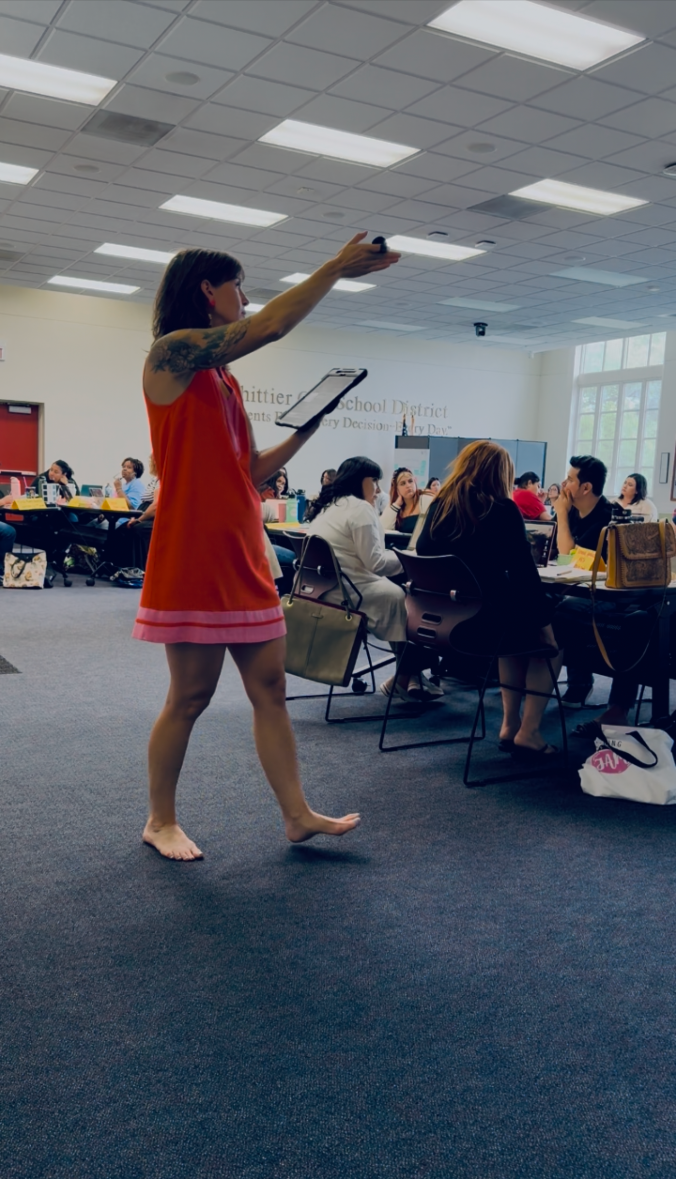 Brittany is training a group of teachers and gesturing to the slide show